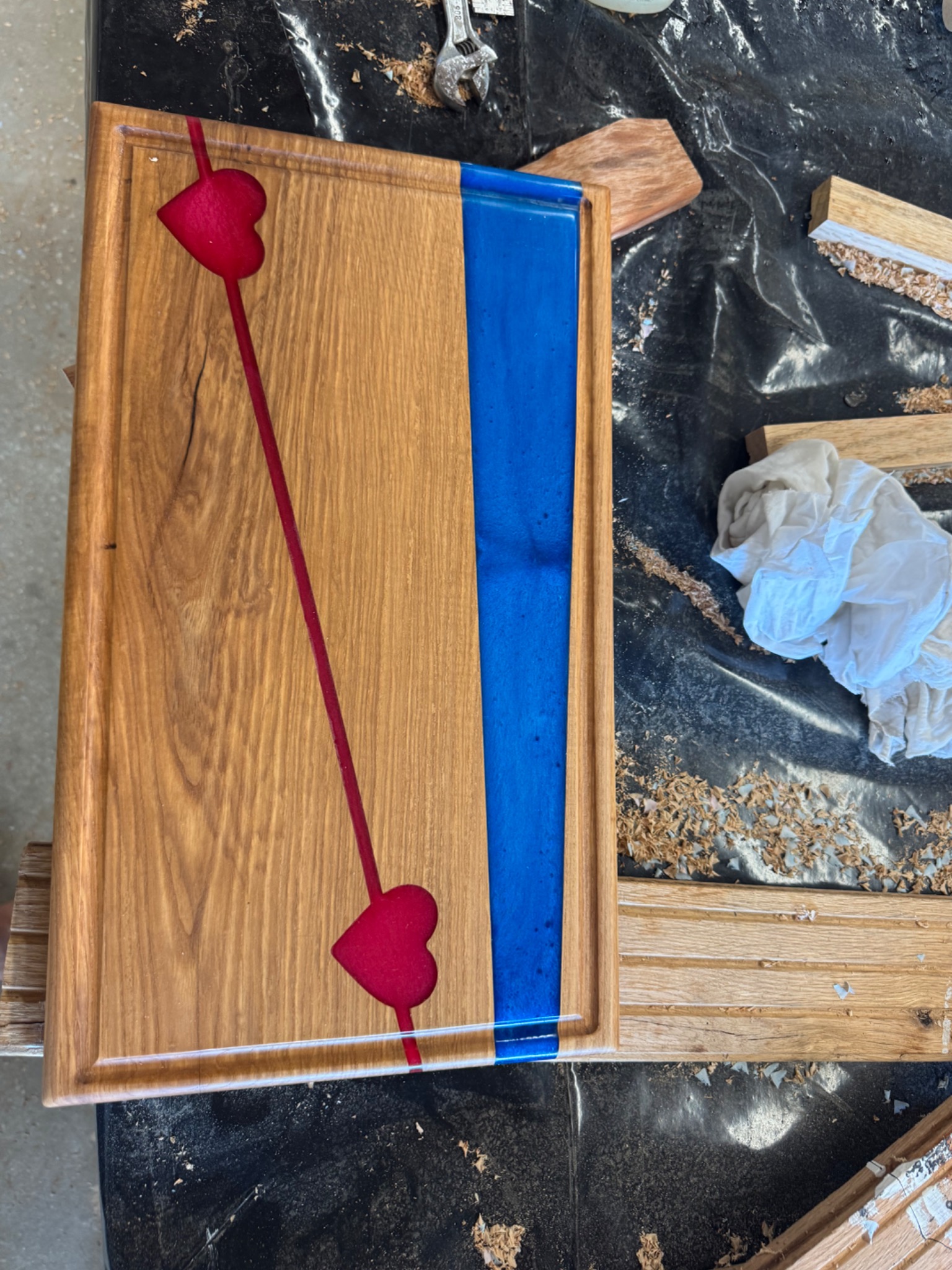 Wooden serving board with vivid red heart accents and a blue epoxy stripe
