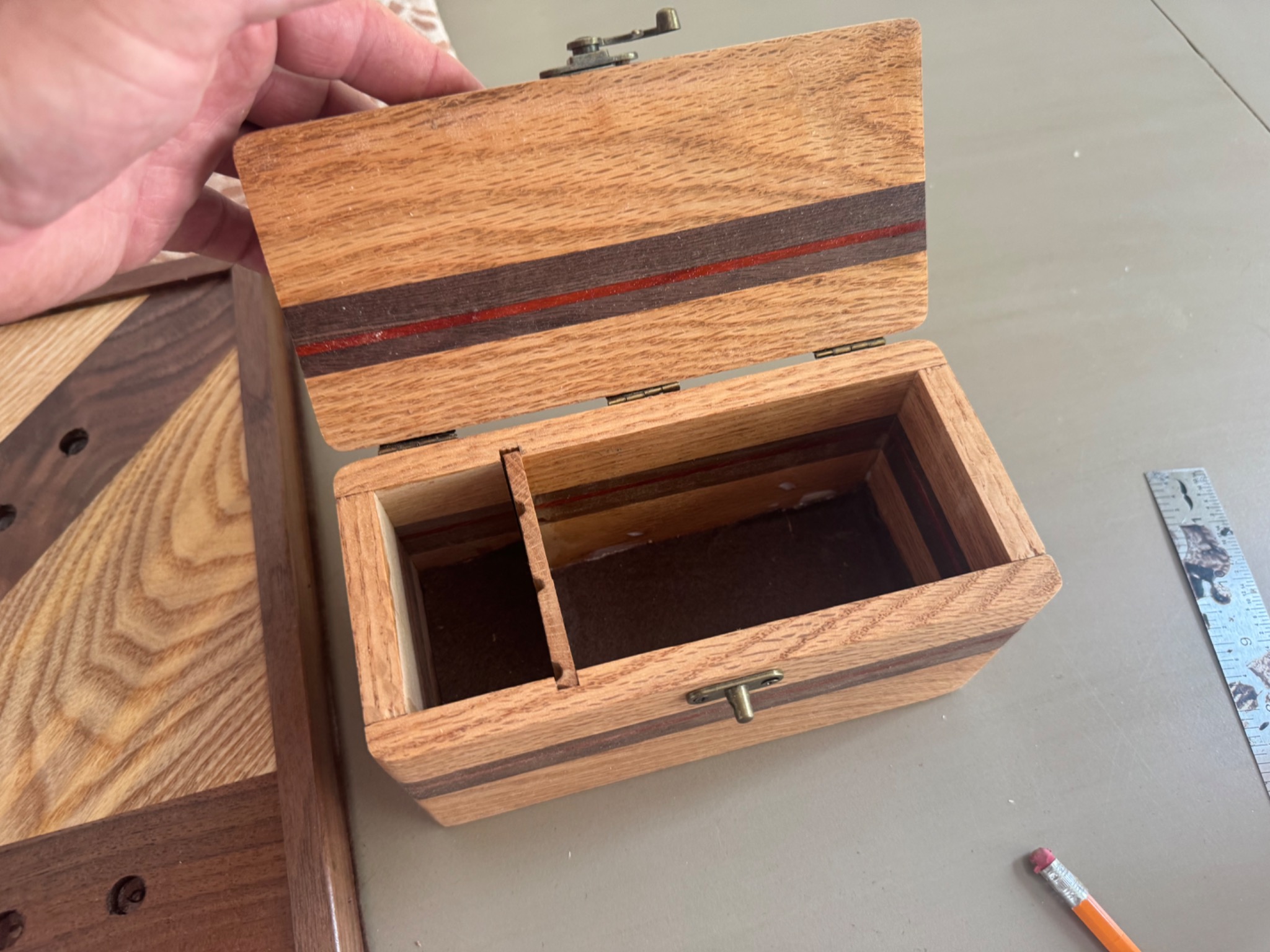 Closed handcrafted wooden storage box with contrasting dark and red accent stripes