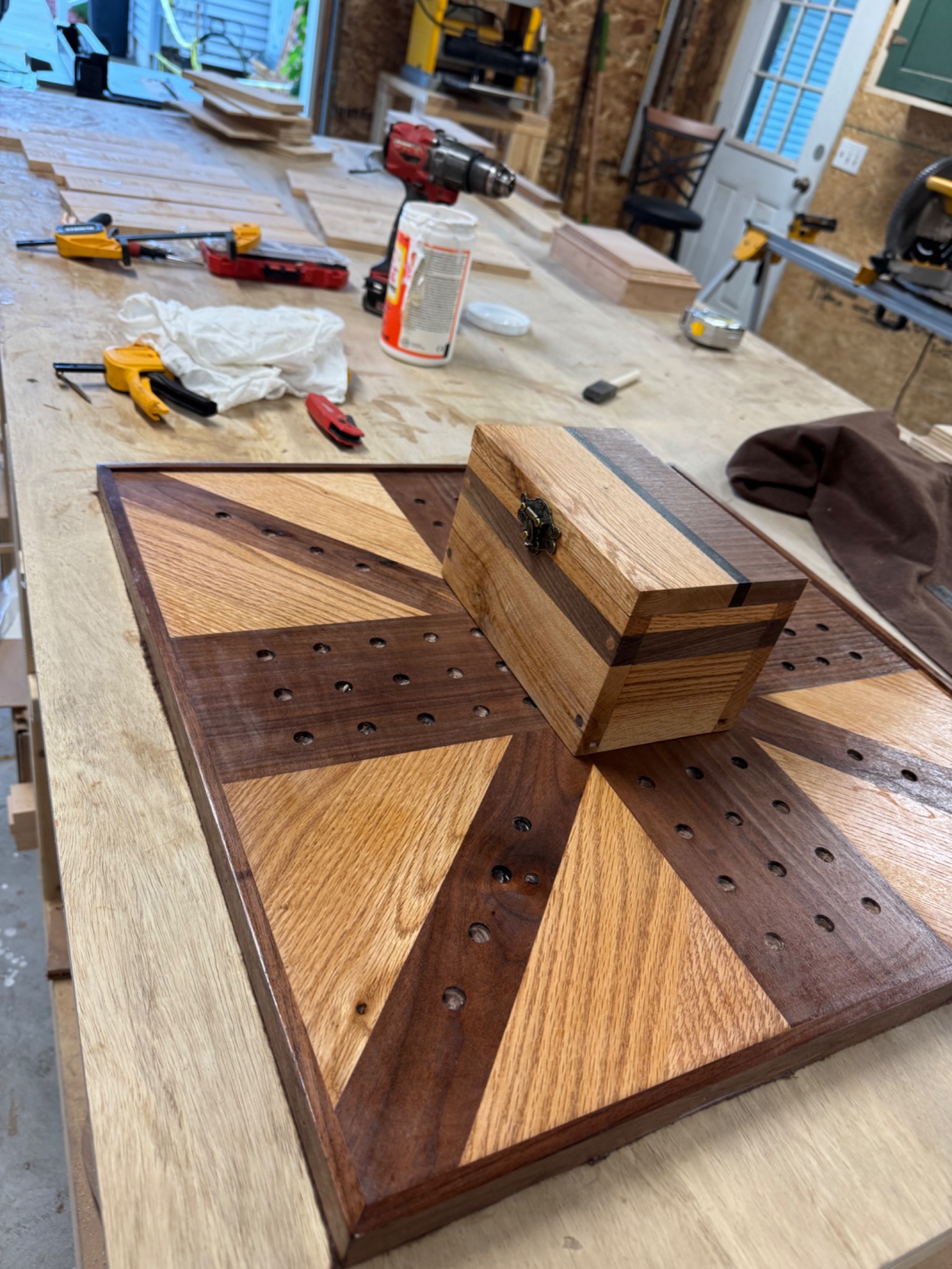 Close view of a finished round wooden cribbage board with carved peg holes